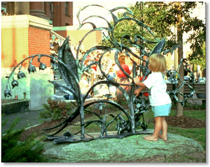 Little girl with park sculpture